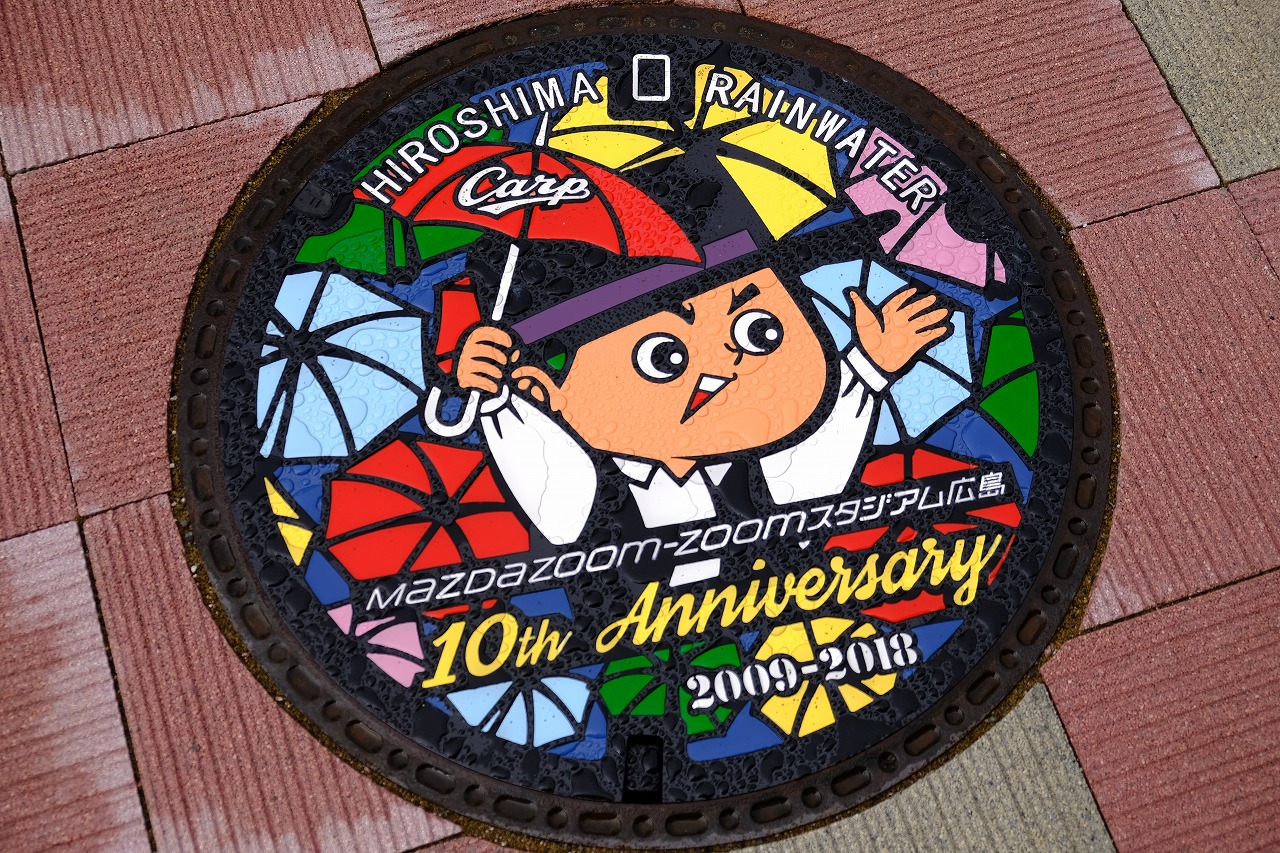 カープ坊やのマンホールに新デザイン マツダスタジアム開場10周年記念 傘まつり をイメージ